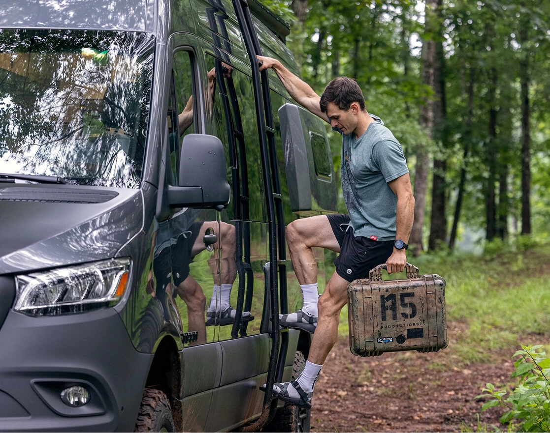 A man climbing the ladder on the side of his Tiffin motorhome